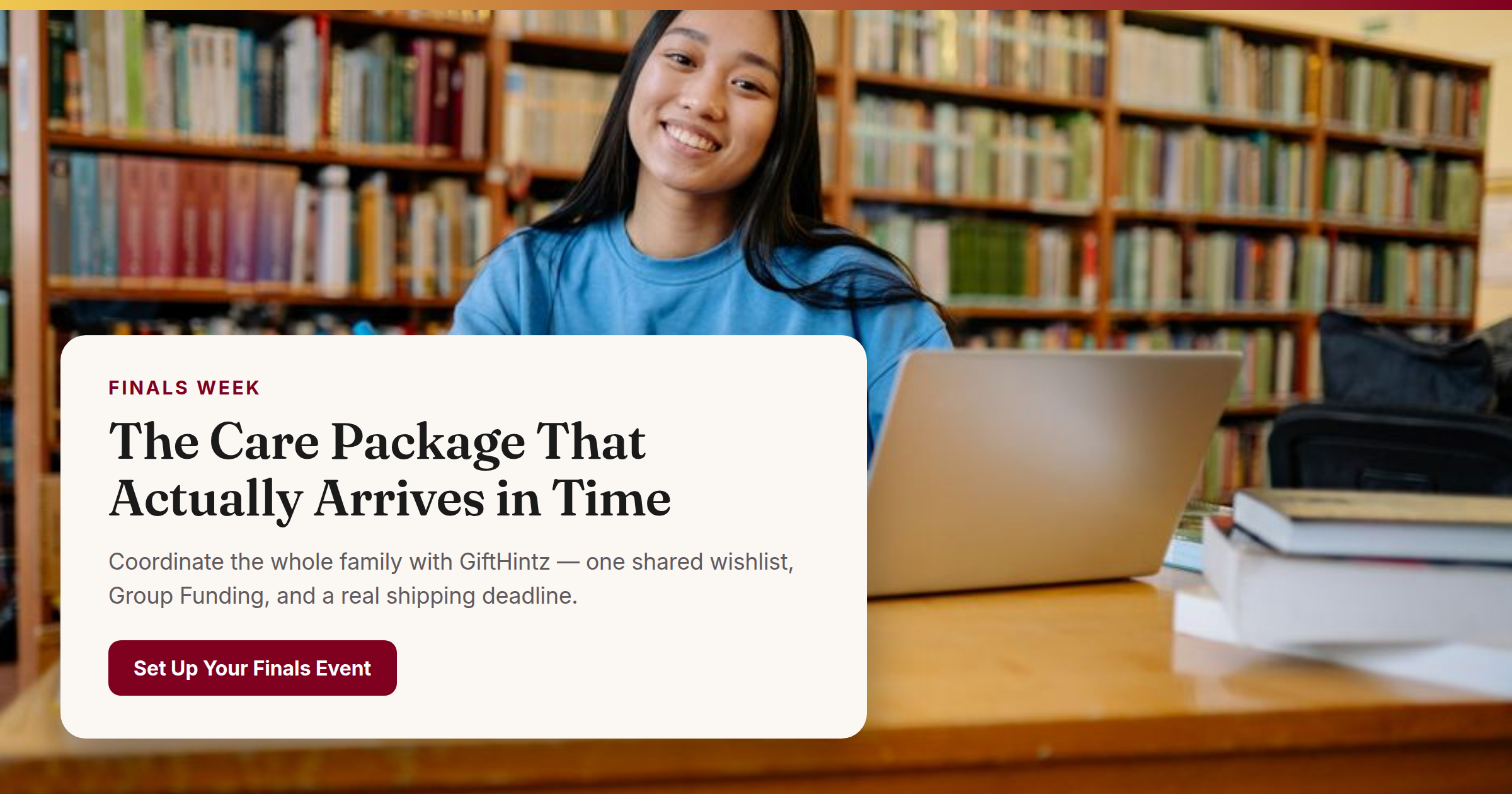 College student smiling and studying in a library with books and laptop open — December finals mood