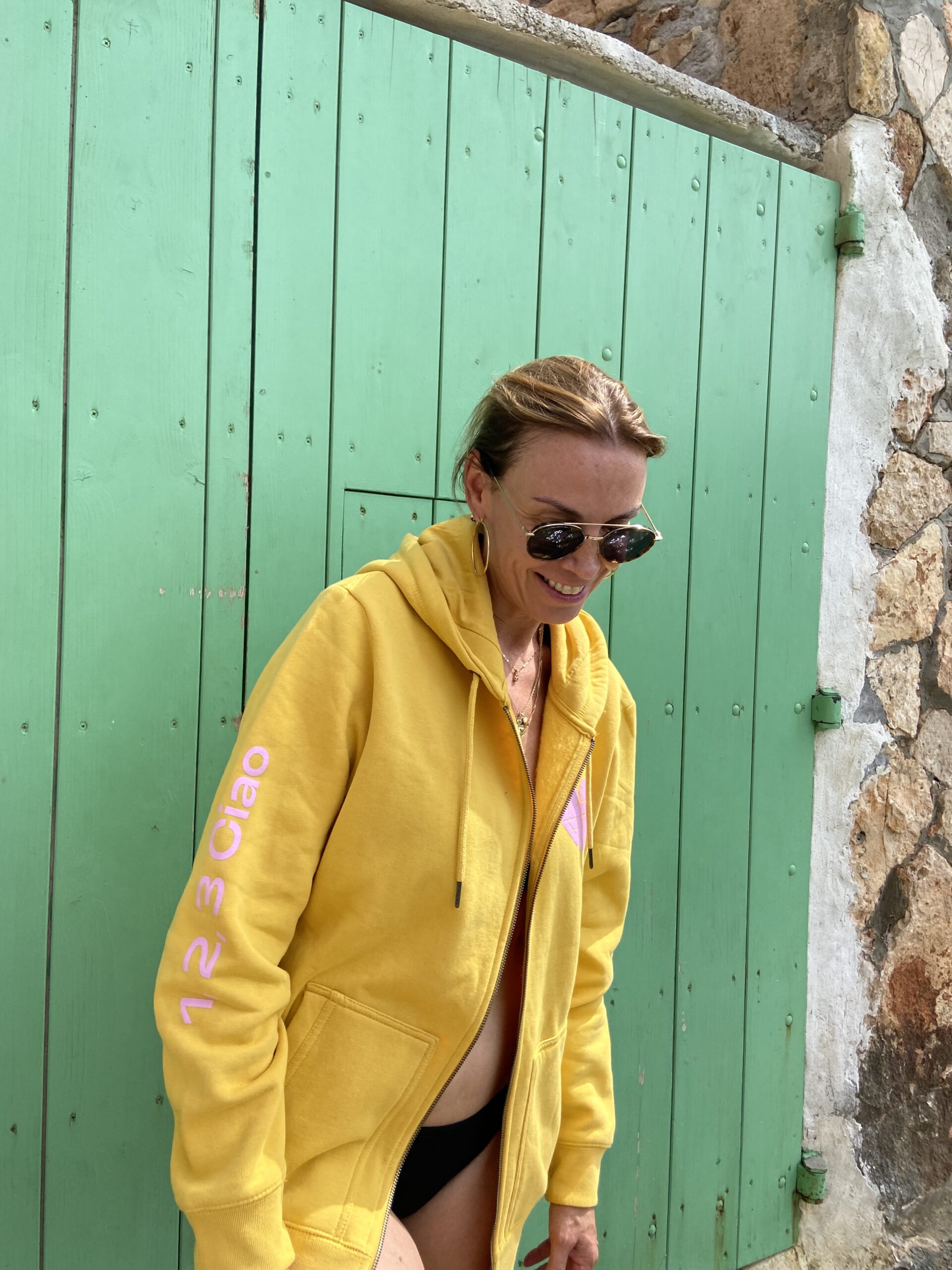 Person wearing a 123ciao hoodie in an everyday lifestyle setting — warm, casual, relatable