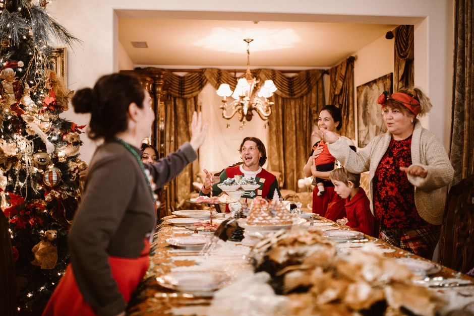 Family gathering around a festive holiday dinner table, celebrating with warmth and laughter