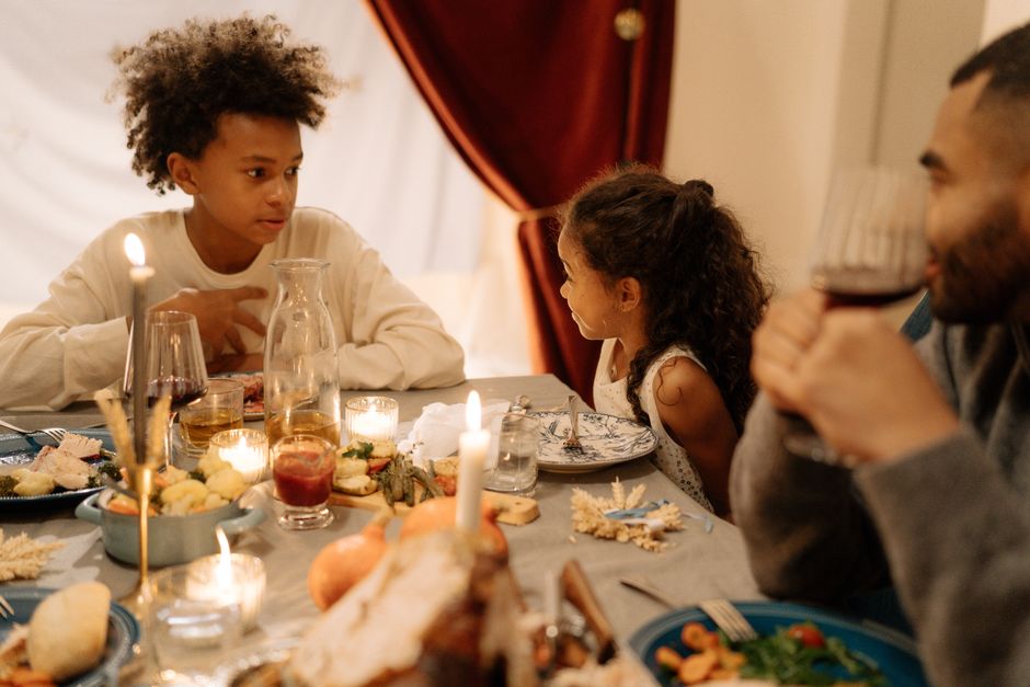Warm family gathering around a candlelit dinner table sharing a festive meal