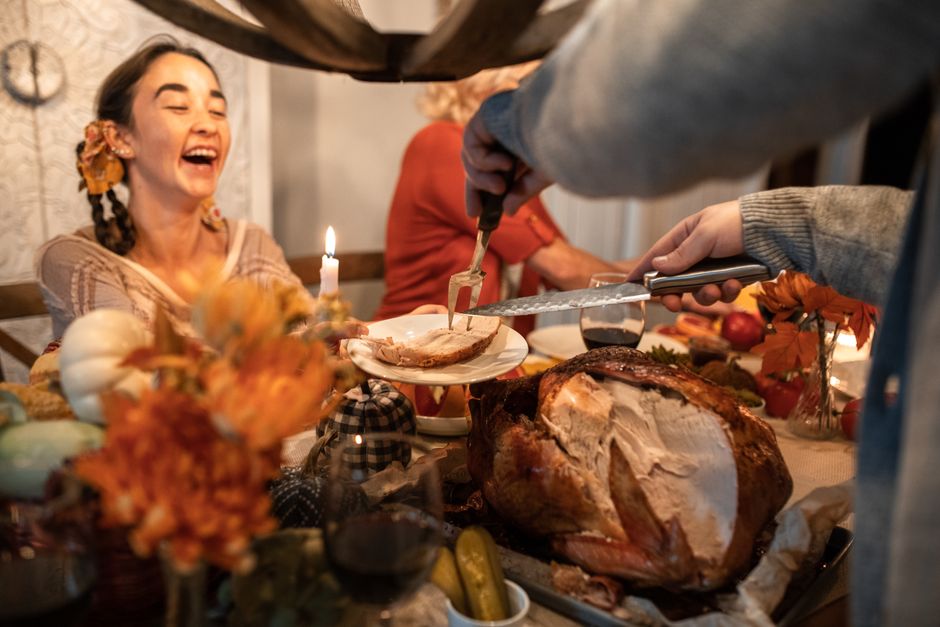 Joyful family gathering around a festive Thanksgiving turkey dinner indoors